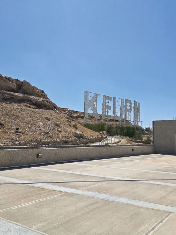 The giant KFUPM letters on the hill above the campus road